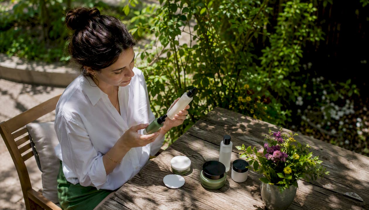 Woman comparing skincare products at home vanity