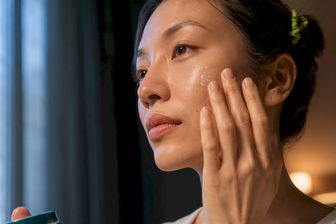 Person applying serum during morning and night routine
