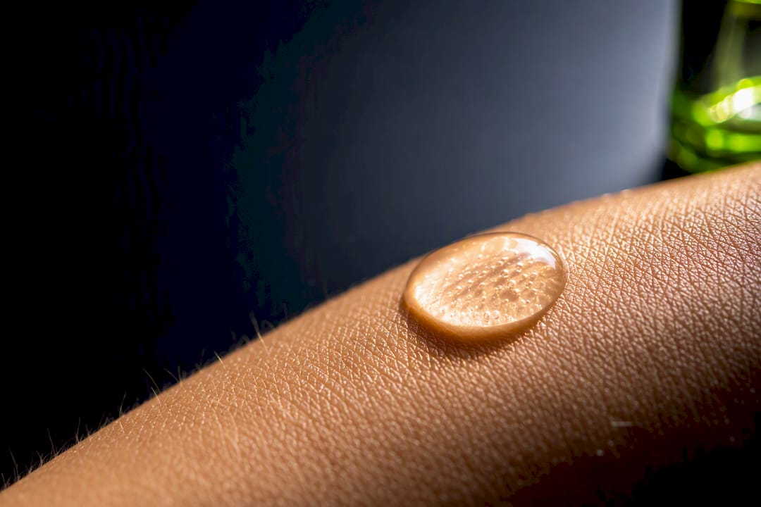 Serum droplet beside detailed skin texture